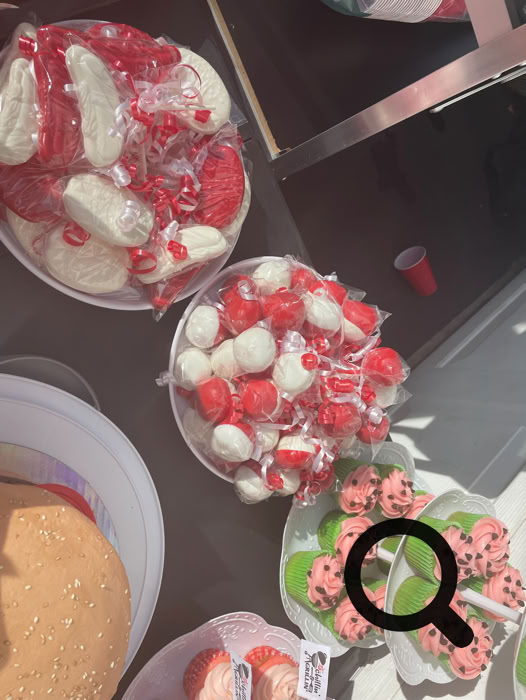 Charming dessert table setup featuring personalized cake pops and a tiered cake, perfect for celebrations.